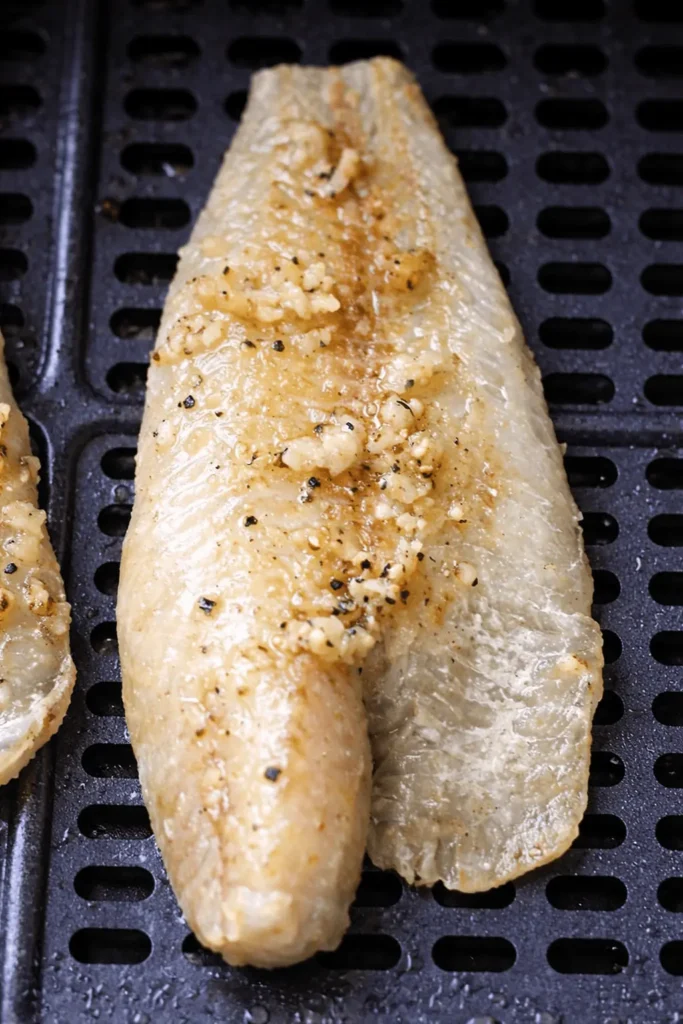 Goldbraun gegartes Seelachsfilet im Korb – Seelachs aus der Heißluftfritteuse mit Knoblauch-Butter.