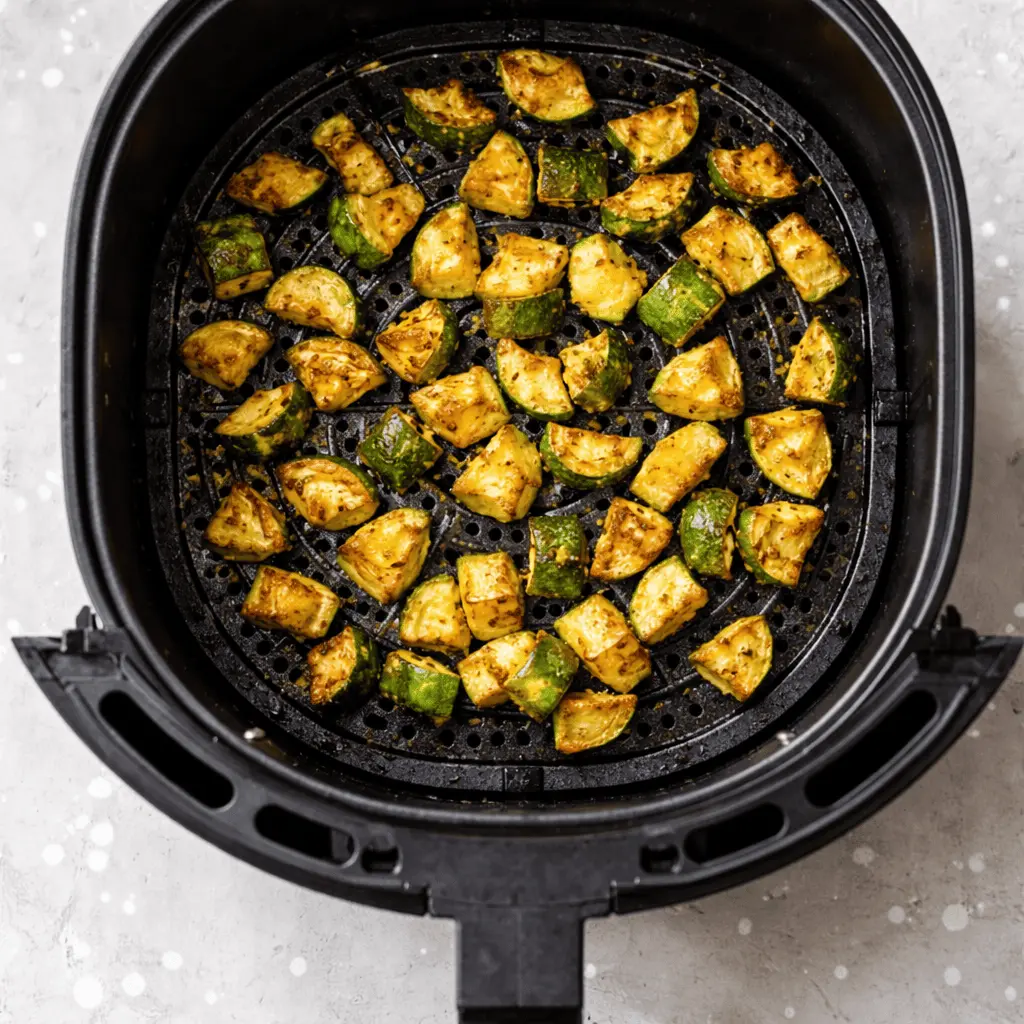 Knusprige Zucchini im Airfryer, goldbraun gebacken, in einem Airfryer-Korb mit Gewürzen